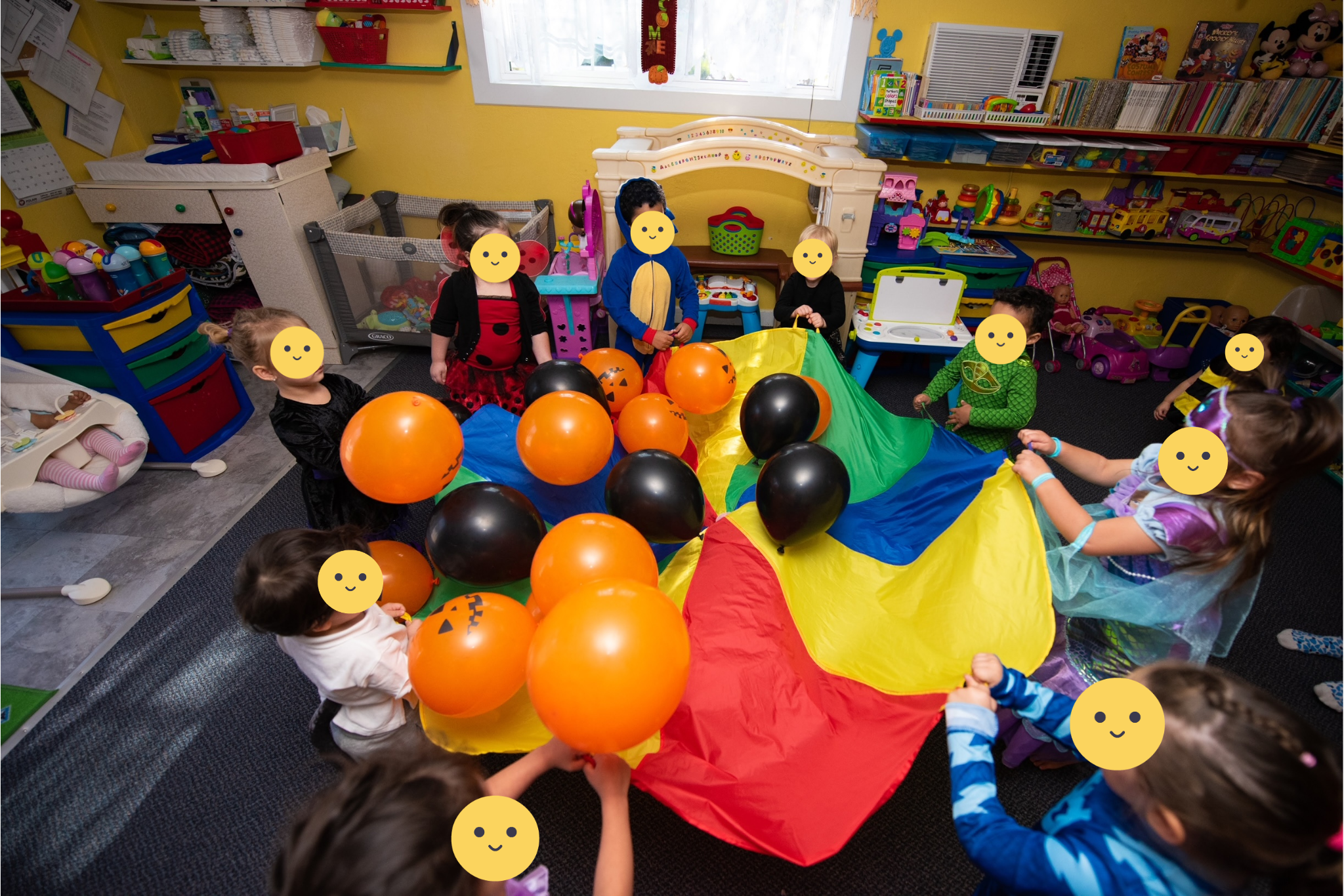 Children playing with a colorful parachute and balloons.